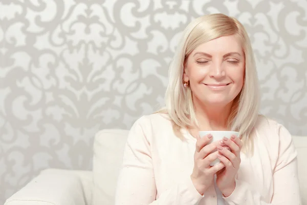 Woman drinks tea on the sofa — Stock Photo, Image