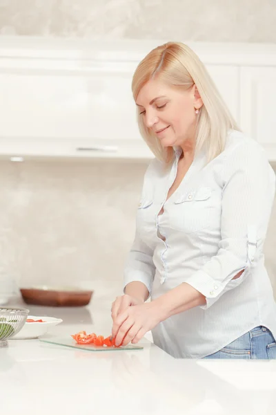 Mujer cocina ensalada en una cocina casera — Foto de Stock