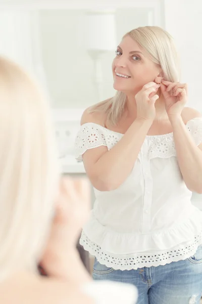 Woman looks at her reflection — Stock Photo, Image