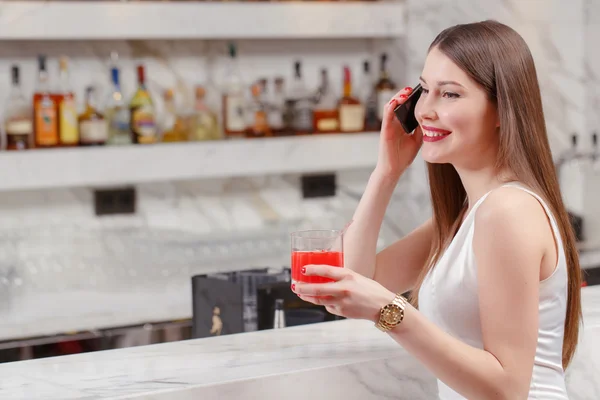 Vrouw spreekt over de telefoon in bar — Stockfoto