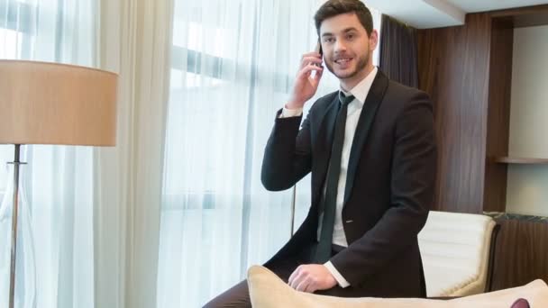 Fiatal jóképű férfi beszél telefonon keresztül — Stock videók