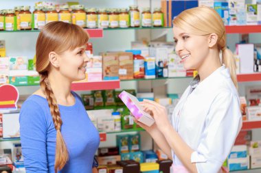 Pharmacist and a customer choosing medicine clipart