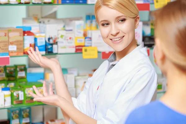 Farmacêutico e um cliente a escolher medicamentos — Fotografia de Stock