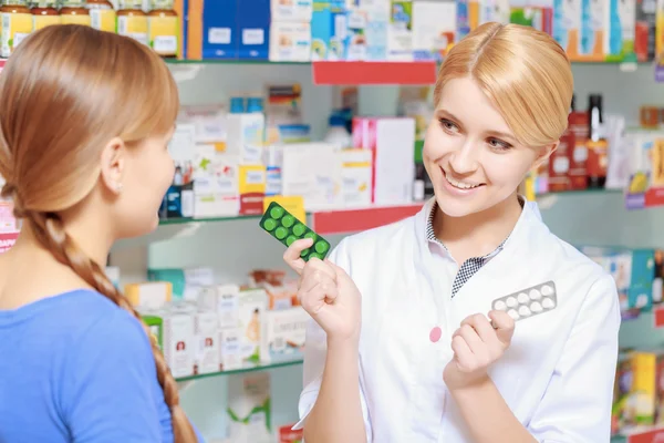 Фармацевт и клиент выбирает лекарства — стоковое фото