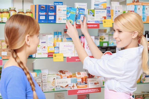Pharmacist and a customer choosing medicine — Stock Photo, Image