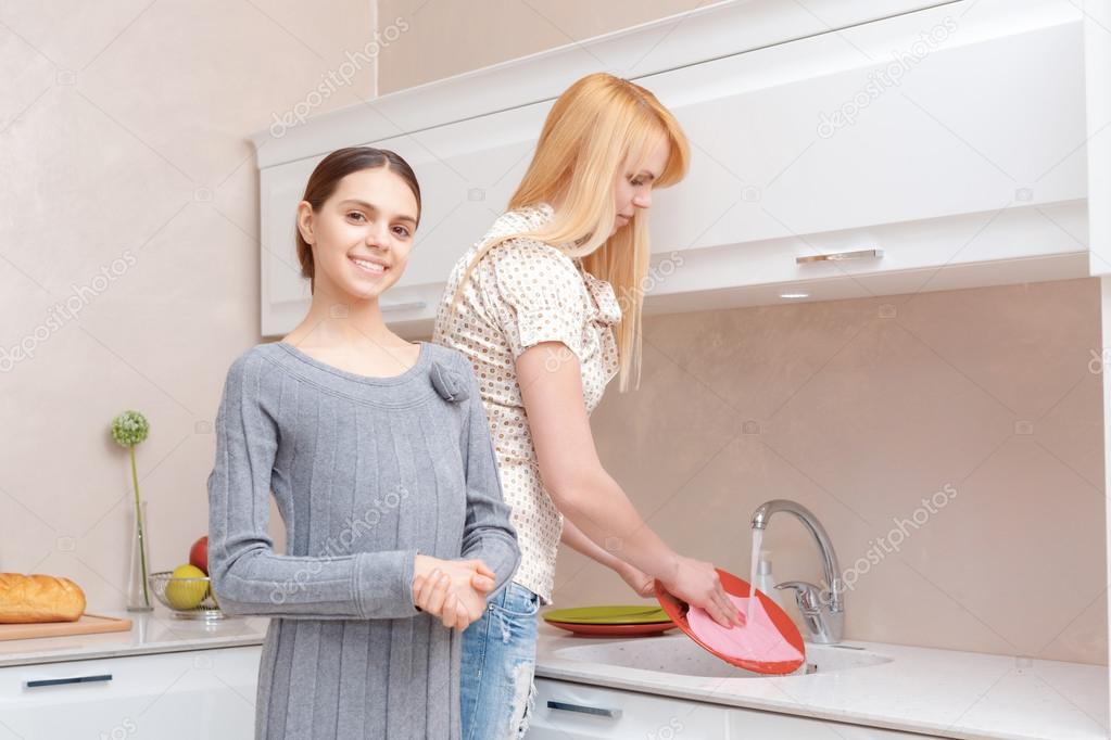 Mother and daughter wash dishes