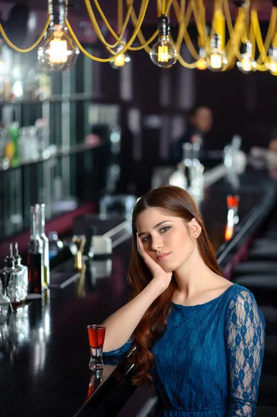 Young woman uses her phone in the bar — Stock Photo, Image