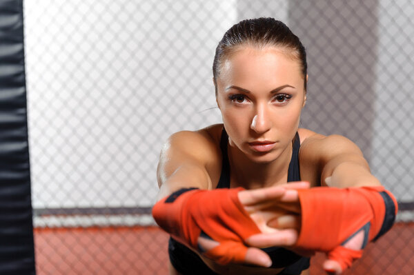 Female kickboxer poses at a ring
