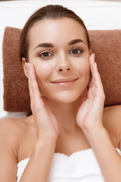 Woman palms her face at spa