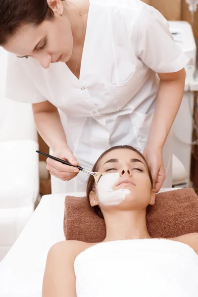 Beautician makes mask to a client — Stock Photo, Image