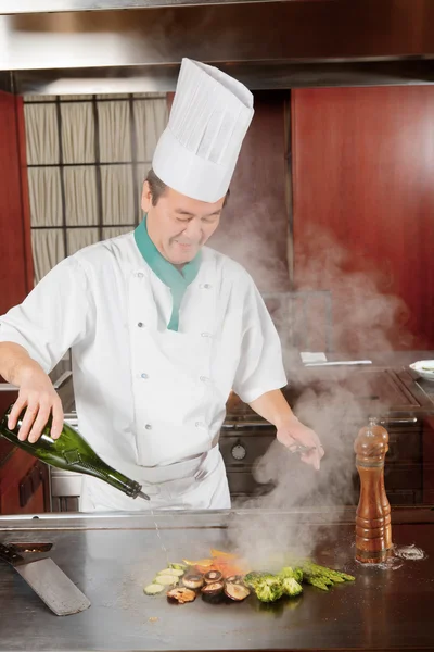 Cook pours sauce on meal — Stock Photo, Image