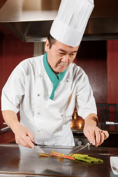 Cook puts vegetables to the dish — Stock Photo, Image