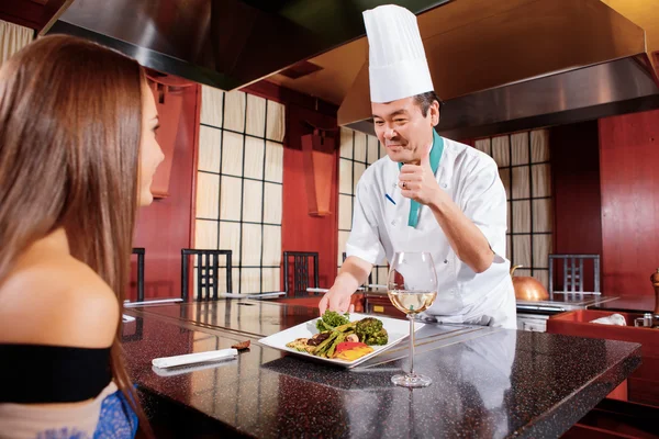Cook serves dish to a client — Stock Photo, Image