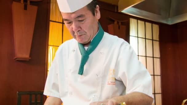 Tracking shot of Japanese chef standing near metal hot plate — Stock Video