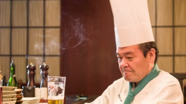 Satisfied Japanese chef sitting in kitchen — Stock Video