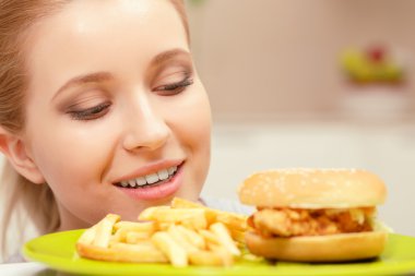 Genç kadın ve fast food yemek