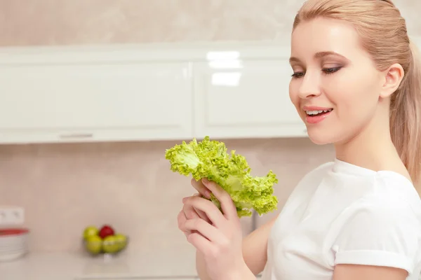 Lady smiles while looking at salad — Stock Photo, Image