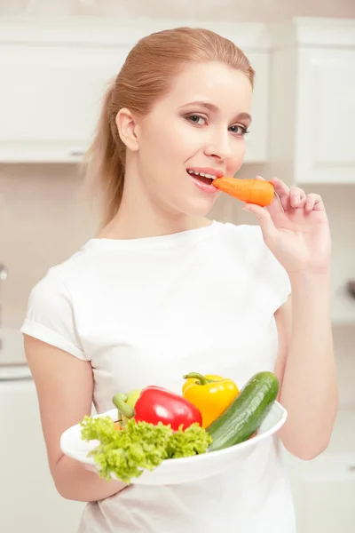 Woman holds plate with vegetables — Stock Photo, Image
