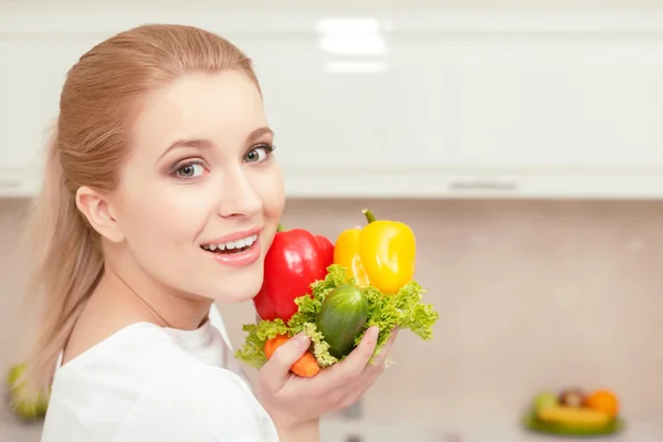 Woman holds vegetables in her hands — Stock Photo, Image