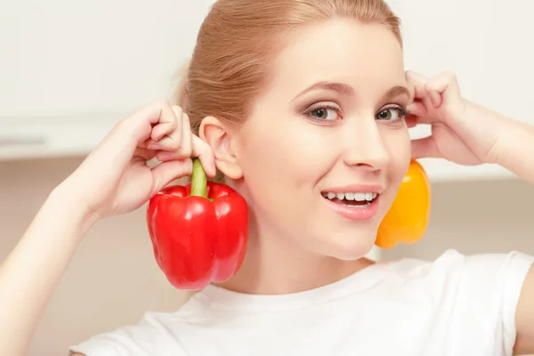 Mujer joven sonriendo y sosteniendo pimienta — Foto de Stock