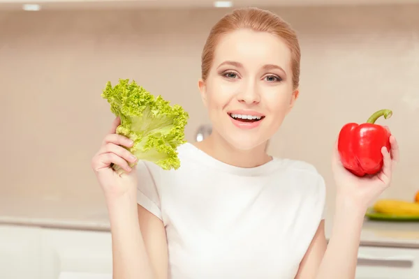Kvinnan har grönsaker i händerna — Stockfoto