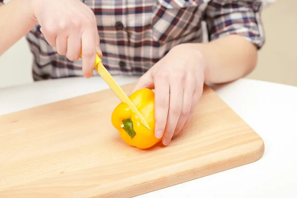 Pimiento amarillo que se corta en la tabla de cortar —  Fotos de Stock