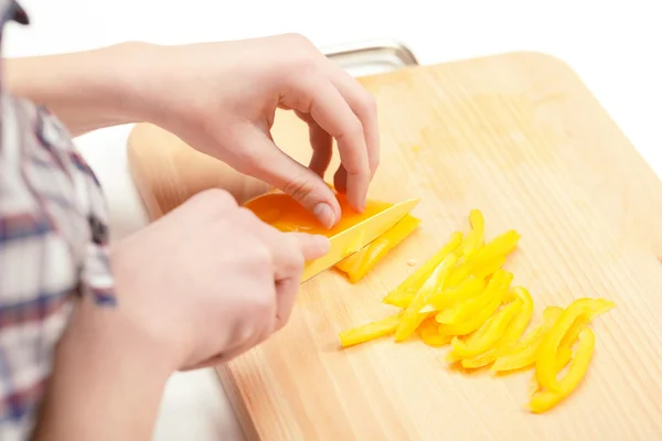 Pimiento amarillo que se corta en la tabla de cortar —  Fotos de Stock