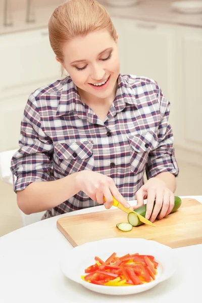 Woman cuts cucumber and pepper — Stock Photo, Image