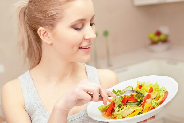 Mujer joven cocina ensalada — Foto de Stock