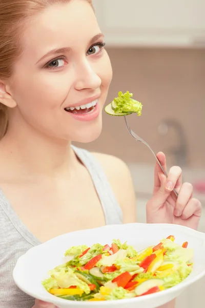 Ung kvinna kockar sallad — Stockfoto