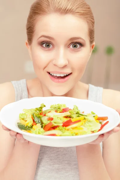 Ung kvinna kockar sallad — Stockfoto