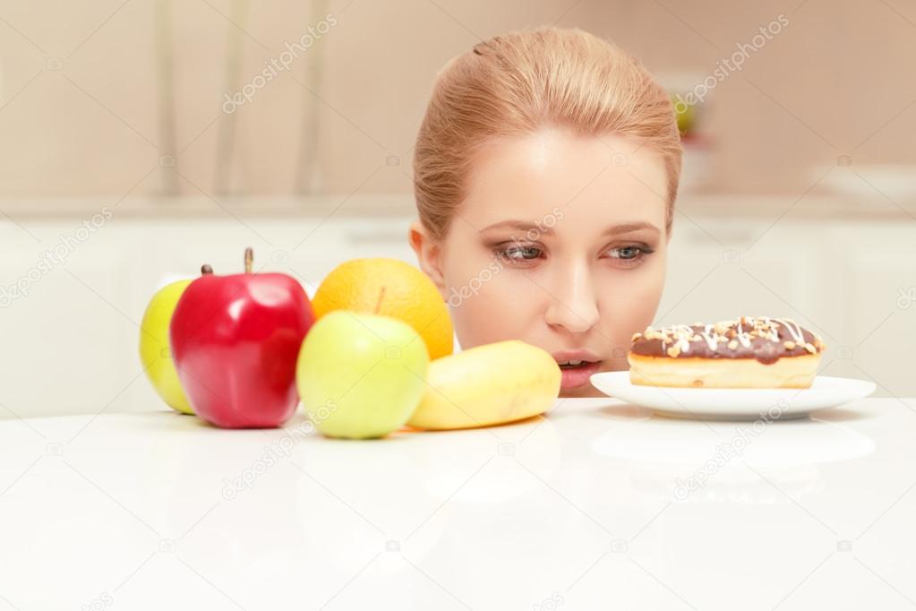 Woman looks at donut and wants to eat it