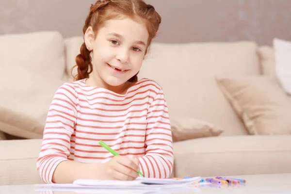 Kleines Mädchen sitzt und zeichnet — Stockfoto