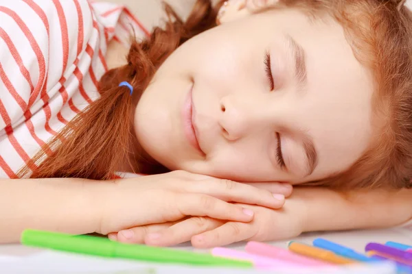 Lying little girl on desk — Stock Photo, Image