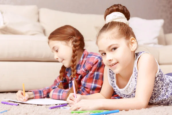 Deux petites filles allongées sur le tapis — Photo