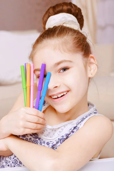 Pequena menina sorridente mostrando marcadores — Fotografia de Stock