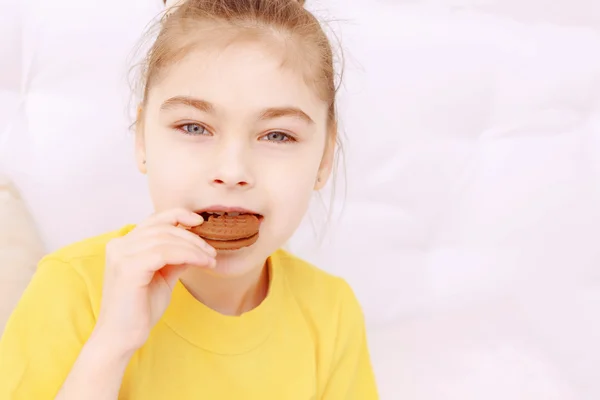 Pretty little girl eating cookie — Stock Photo, Image
