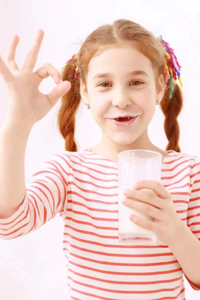 Kis lány pózol pohár tej — Stock Fotó