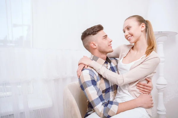 Young lovely couple sitting and hugging — Stock Photo, Image