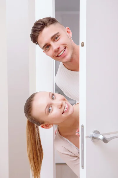 Two nice persons emerge from behind door — Stock Photo, Image