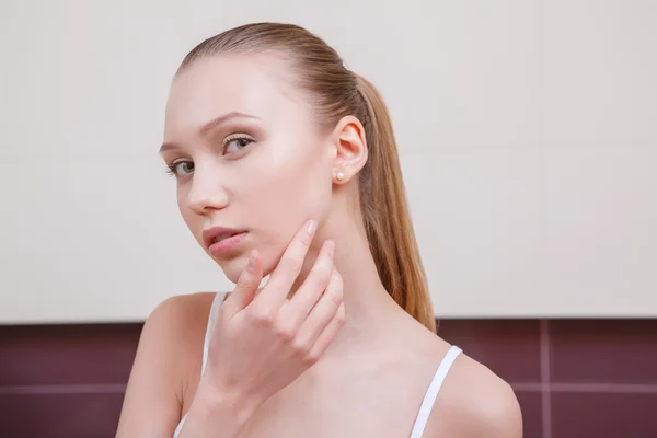 Mujer joven y bonita mirando en el espejo — Foto de Stock