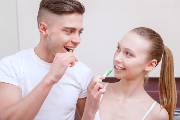 Молодая красивая пара чистят зубы — стоковое фото
