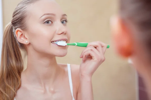 Pretty young woman cleaning her teeth — Stock Photo, Image