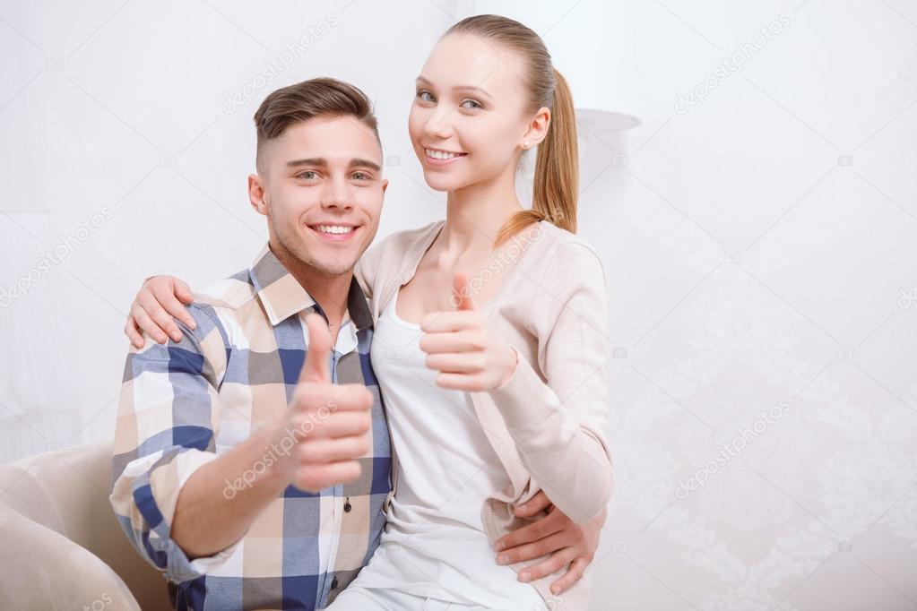 Young-looking guy and girl thumb up