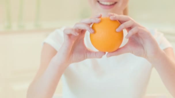 Junge Frau gibt uns frische Orange. Bio-Lebensmittel — Stockvideo