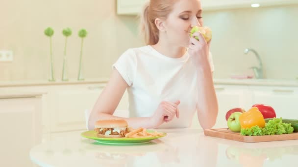 Jovem mulher escolher entre alimentos saudáveis e não — Vídeo de Stock