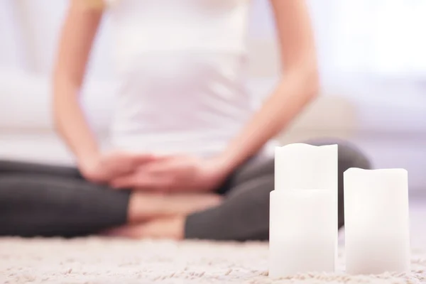 Mulher meditando no fundo de velas brancas . — Fotografia de Stock