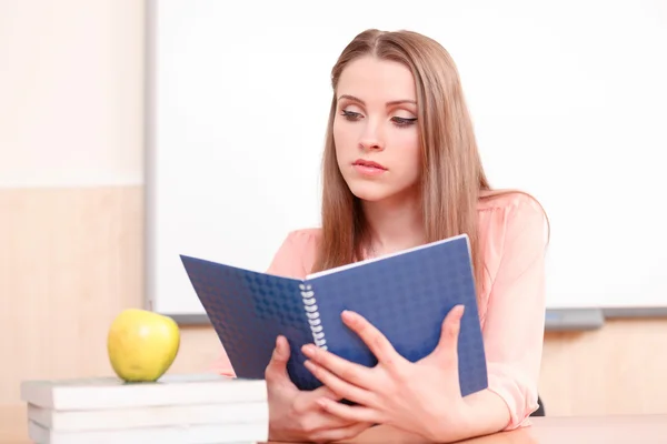 Giovane donna guardando libro copia blu — Foto Stock