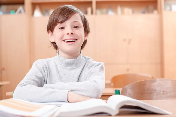 Lächelnder Junge am Schreibtisch — Stockfoto