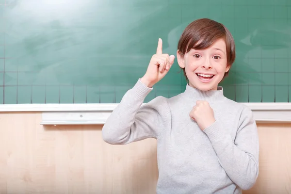 Lächelnder Schüler zeigt mit dem Zeigefinger — Stockfoto